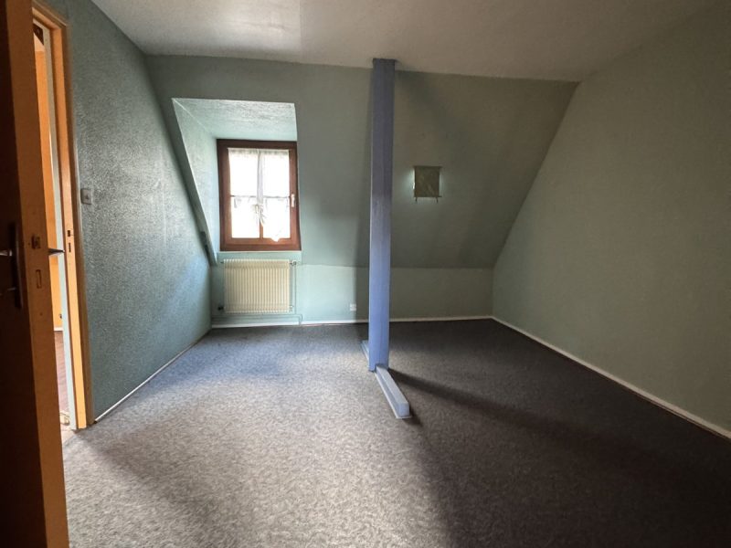 Chambre mansardée aux murs verts au deuxième étage